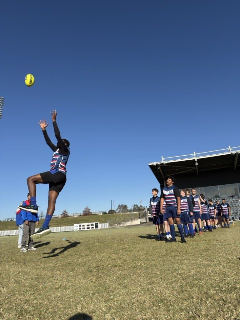 4titude AFL session, participants practising kicking and marking on a grass oval